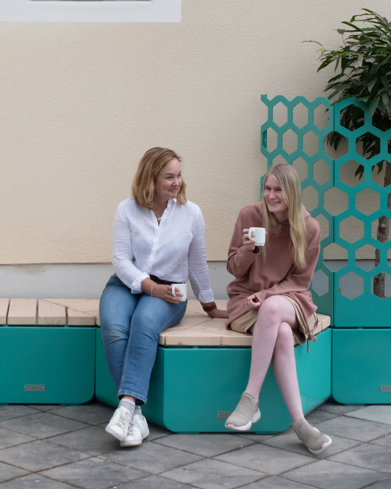 Modular Rosenlund outdoor casual seating combination in blue, 2 women are sitting and talking.